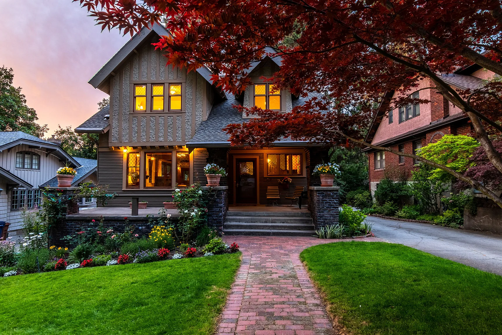 Family home at dusk with warm lights on in the windows