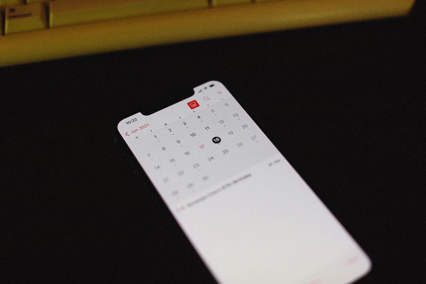 Smartphone showing a monthly calendar on a desk