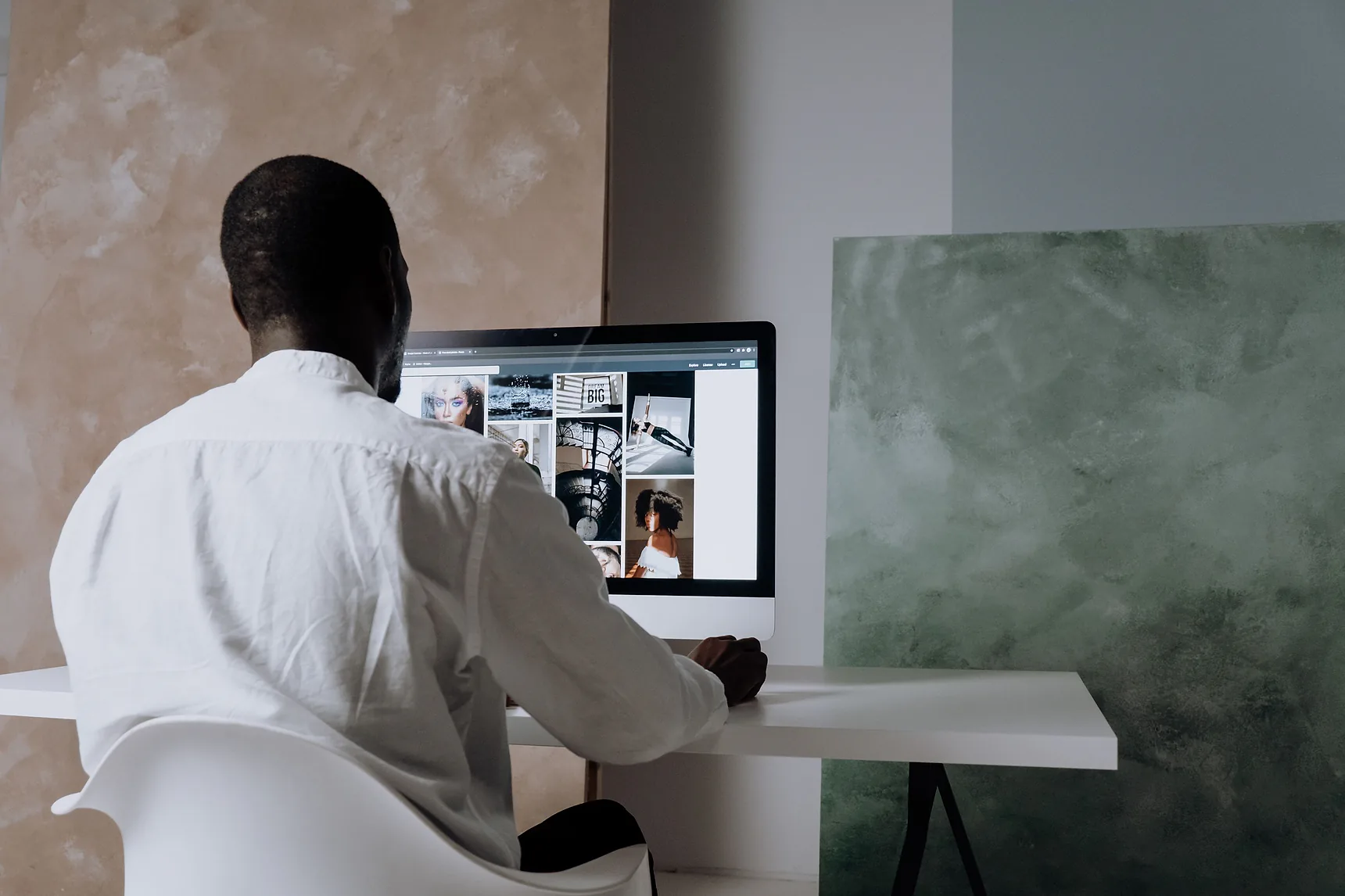 Designer at a desktop computer reviewing a website layout
